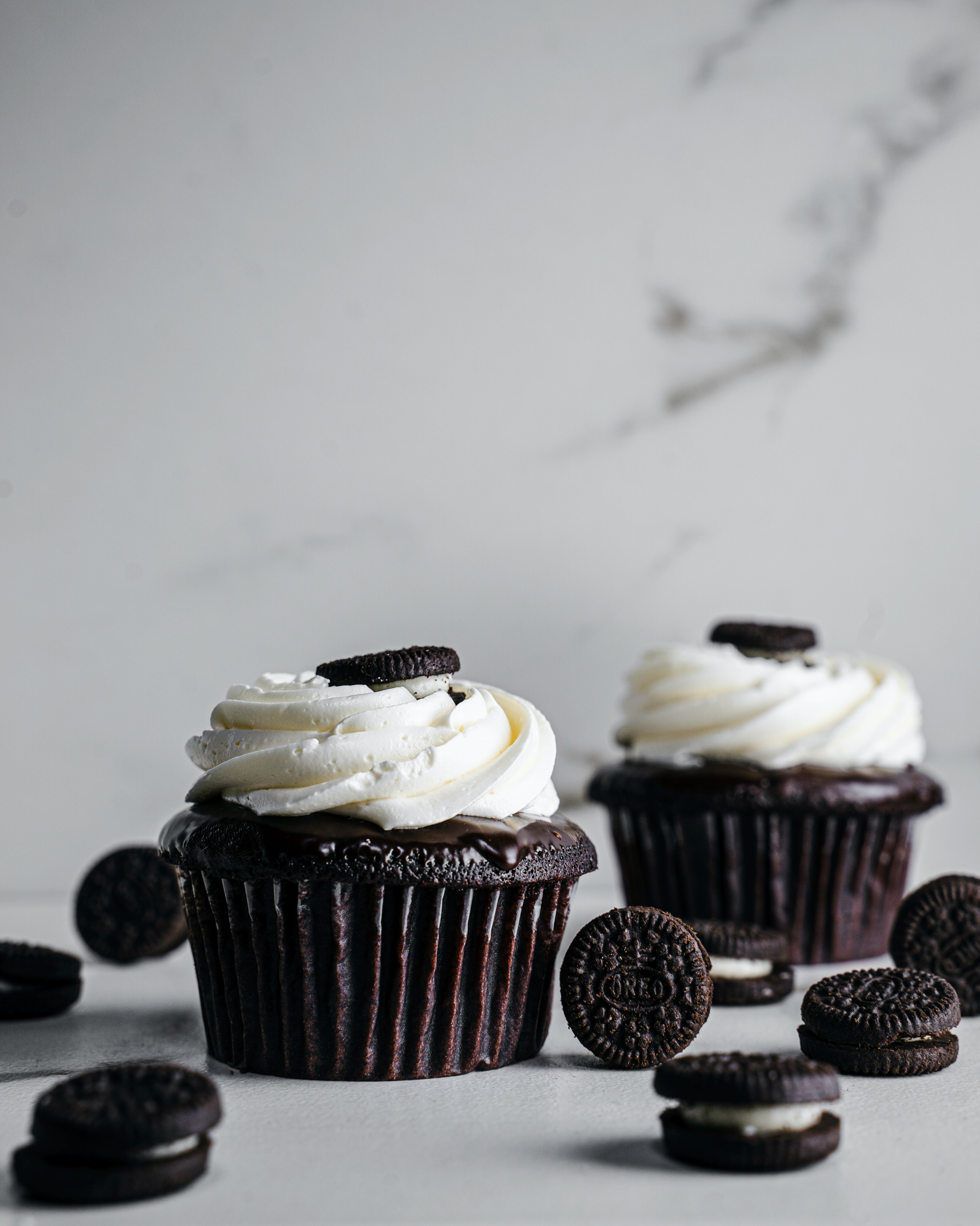 Dark Chocolate Cupcake with white cream frosting and Oreo cookie on top