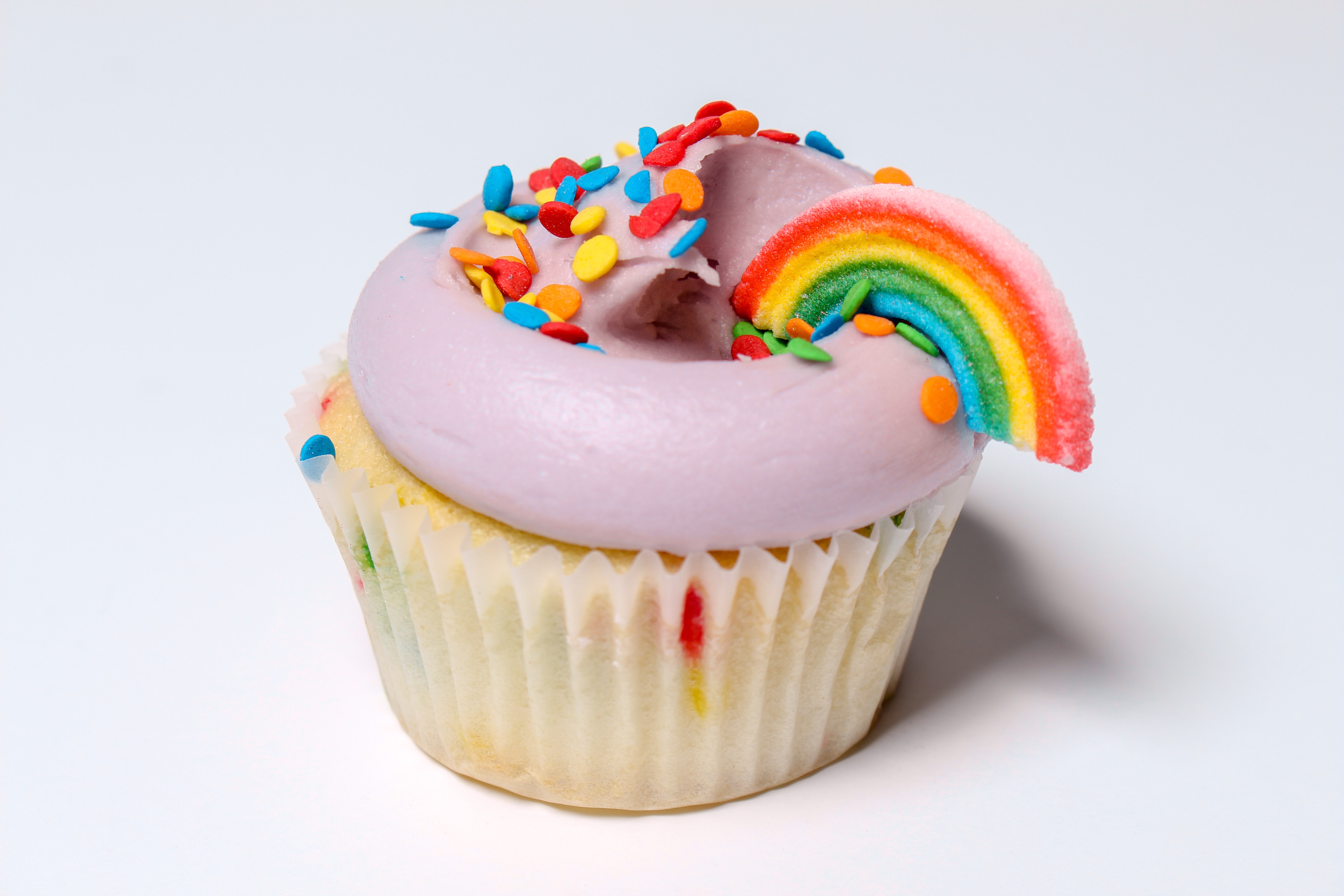 Cupcake with pink frosting and magical rainbow sprinkles on top